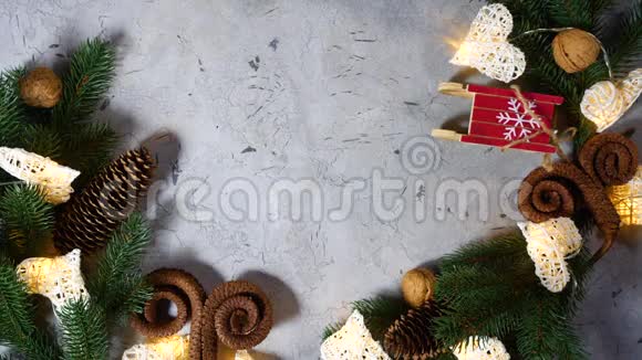 圣诞礼物被扔给其他节日玩具附近有松树和云杉枝小雪橇锥和坚果视频的预览图