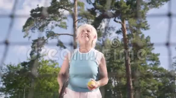 成功快乐成熟的女人赢得了网球锦标赛那位老太太用球拍举起手来视频的预览图