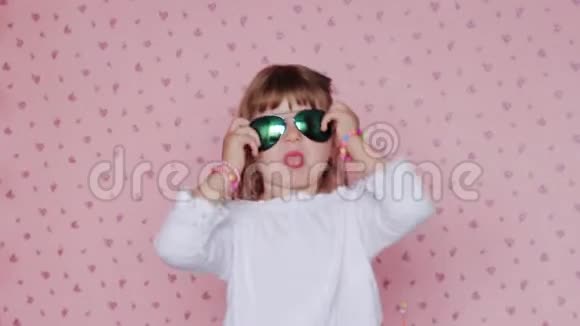 带着大墨镜的小女孩做鬼脸玩得开心孩子和积极的情绪视频的预览图