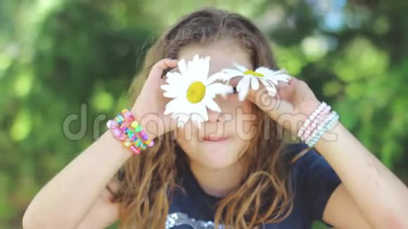 可爱的头发湿的小女孩在玩沙斯塔雏菊花做脸玩得开心积极的情绪慢动作视频的预览图