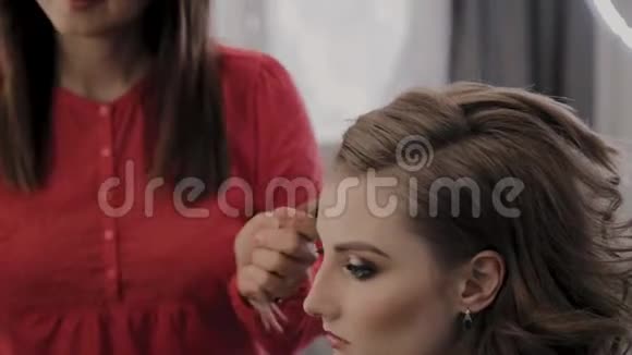 专业的理发师为拍照片女孩的发型视频的预览图