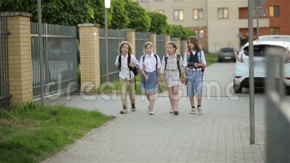 孩子们带着背包去学校附近的公园两个男孩和两个女孩放学后回家回去视频的预览图