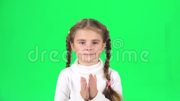 两条辫子的女孩在绿色的屏幕上发送空气亲吻和微笑慢动作视频的预览图