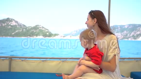 一个女人和她的小儿子在船上婴儿躲避海水视频的预览图