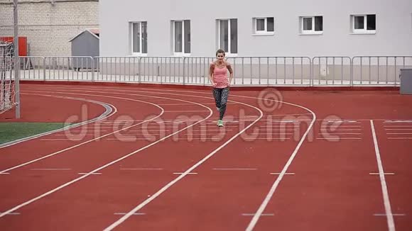 田径运动员女子在体育场跑步前热身慢动作视频的预览图