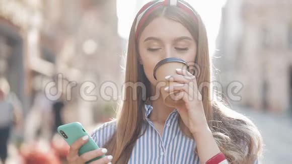 美丽的白种人年轻女孩的肖像棕色头发头戴条纹衬衫使用她的智能手机和视频的预览图