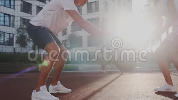 中间射击太慢了年轻的男女运动员在街上表演运球和弹跳球视频的预览图