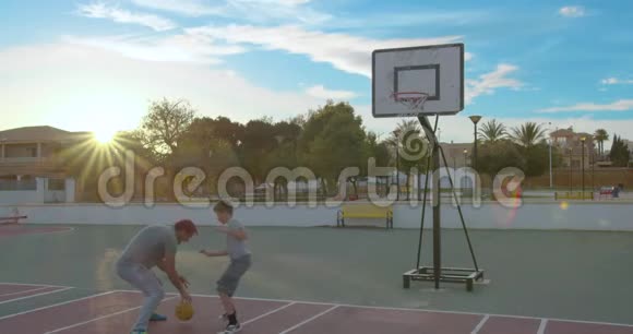 父亲和儿子在公园里玩一天打篮球视频的预览图