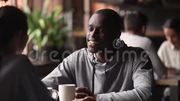 非洲男子喝茶在会上与白种人妇女交谈视频的预览图
