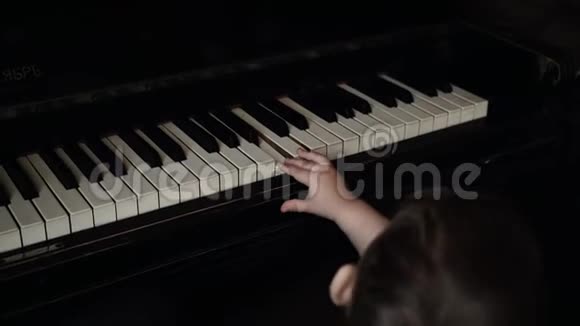 小可爱的小男孩轻轻地按一个钢琴键慢动作视频的预览图