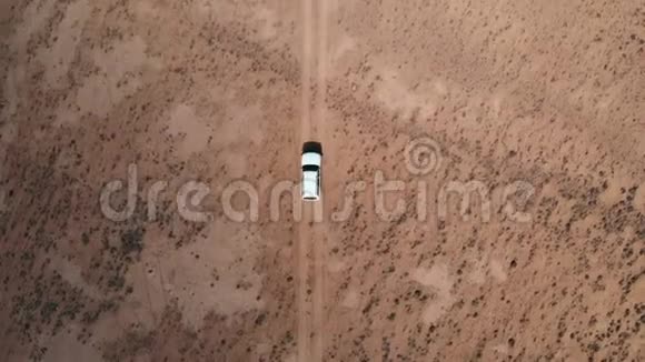 从4x4路的空中飞过汽车沿着砾石小径行驶在沙漠帕米尔高速公路上的白色越野车上方视频的预览图