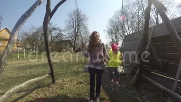 早春母亲带着女孩在复古木秋千上荡秋千视频的预览图