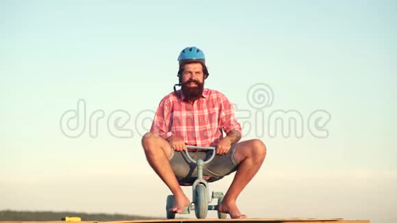 有趣的人玩儿童自行车有趣的疯子父亲节一个长胡子的有趣男人正在骑儿童自行车视频的预览图