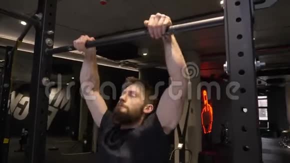成人肌肉运动健美运动员的特写镜头锻炼身体并在健身房室内的酒吧里举起自己视频的预览图
