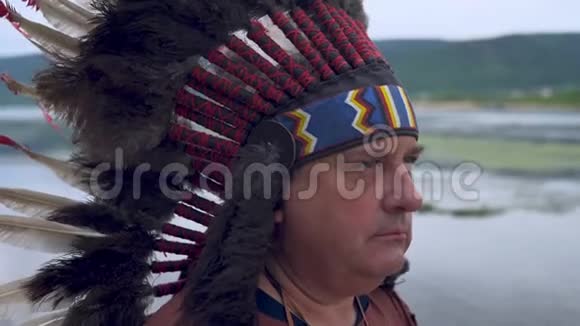 古老的美洲印第安人看着夕阳河流的背景视频的预览图