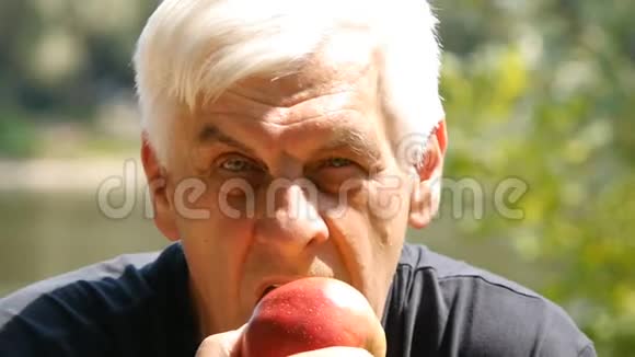 老人吃苹果的肖像快关门吃苹果的人视频的预览图