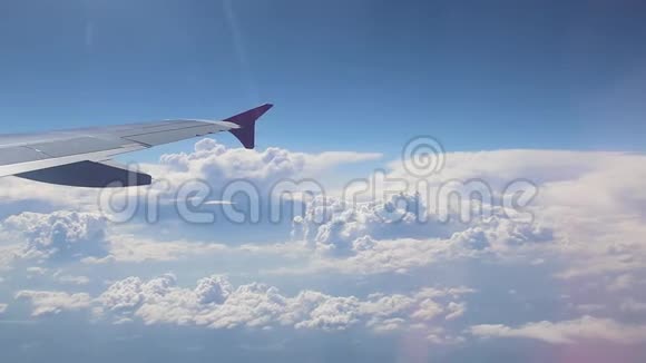 飞机飞行一架飞机的机翼在云层上方飞行天空是夕阳从平面的窗口查看视频的预览图