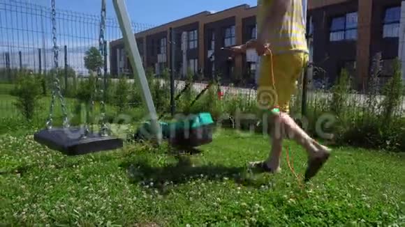 年轻人在儿童游乐场用电动割草机割草万向节运动视频的预览图