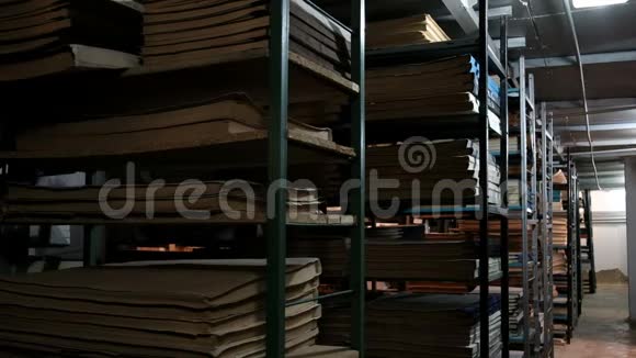 一个穿着白色衬衫的年轻人在书架之间徘徊环顾四周放置旧图书馆或档案视频的预览图