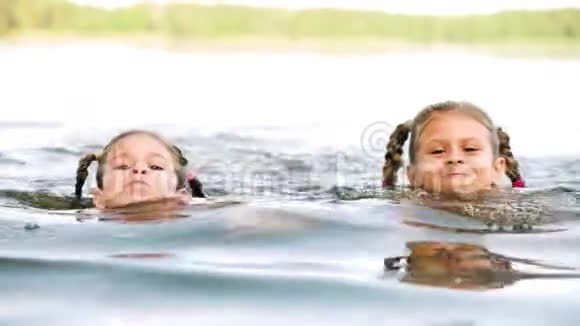 迷人的小女孩在湖里游泳玩得开心视频的预览图