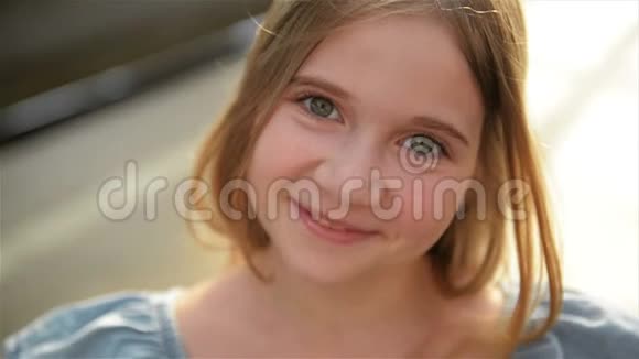 特写一幅美丽的小女孩的肖像她长着浅长的头发绿色的大眼睛在镜头中轻松地看着视频的预览图