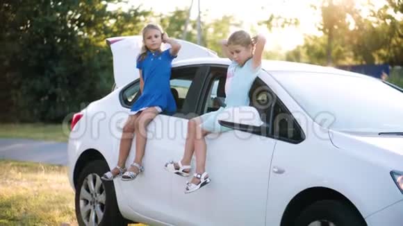 两个小妹妹坐在车门上视频的预览图