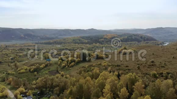 秋天鸟瞰群山和丘陵的小村庄视频的预览图