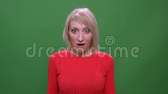 中年金发短发模特在绿色背景下的镜头中表现出积极的惊喜视频的预览图
