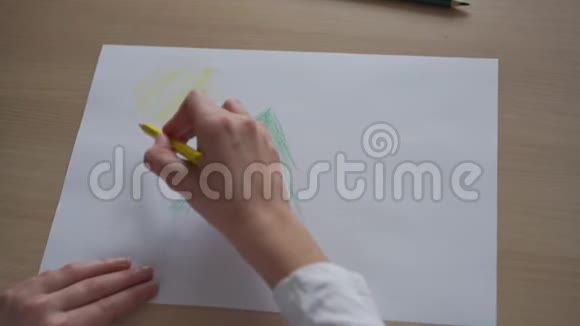 少女在纸上画绿松树和黄日视频的预览图
