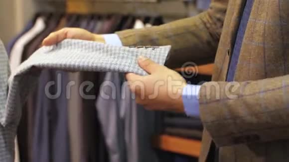 男人在服装店里看夹克的质量视频的预览图