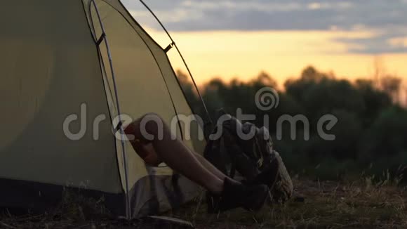 年轻人在帐篷里醒来伸伸手打哈欠野营度假视频的预览图
