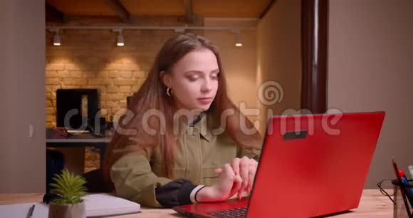年轻的十几岁女孩在办公室里用笔记本电脑工作的肖像是乐观和积极的视频的预览图