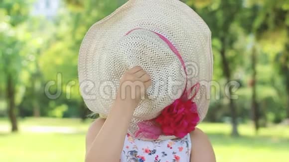 小女孩拿着草帽玩耍摘下帽子微笑着动作缓慢视频的预览图