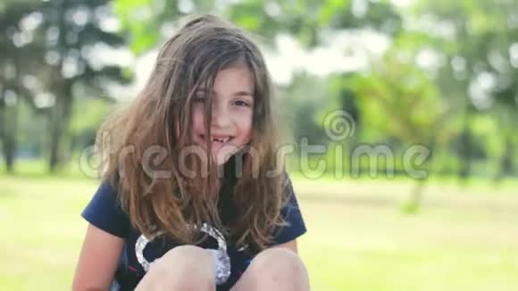 头发凌乱的小女孩在公园里笑着积极的情绪视频的预览图