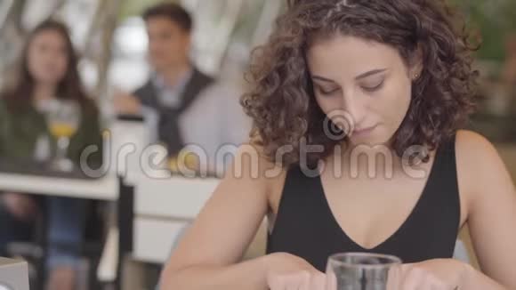 可爱的年轻卷曲的女人在街头咖啡厅吃美味的肉菜和土豆享受甜点放松的女孩视频的预览图