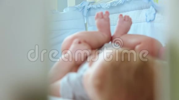 一个小蹒跚学步的孩子在婴儿床笑侧视通过一个小床改变焦点快乐的童年视频的预览图