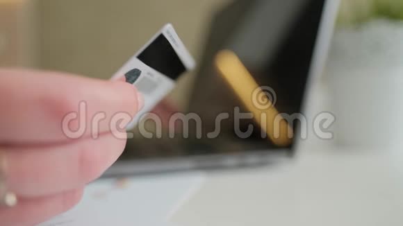女人拿着信用卡打字使用笔记本电脑上网购物视频的预览图
