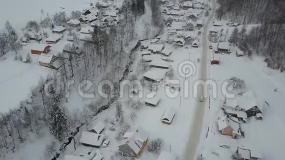 冬季的乡村景观喀尔巴阡村冬季公路上行驶的汽车的鸟瞰图鸟雪的视野视频的预览图