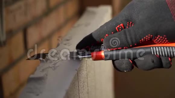 穿黑色和红色手套的工人切割绝缘板视频的预览图