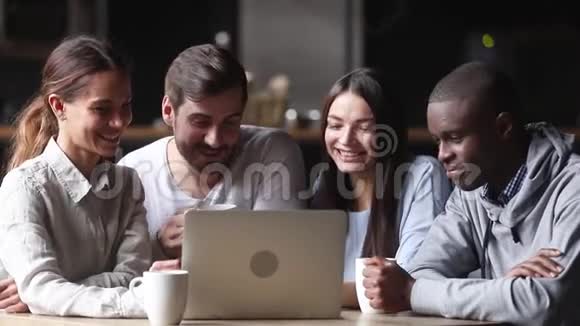 快乐的不同朋友看音乐视频跳舞坐在桌子上视频的预览图