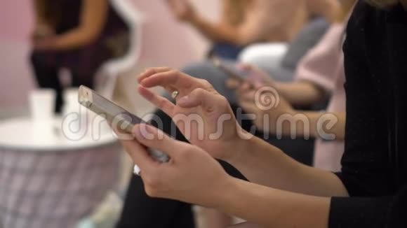 特写女性手握智能手机在触摸屏上输入文本女人坐在电话会议上视频的预览图