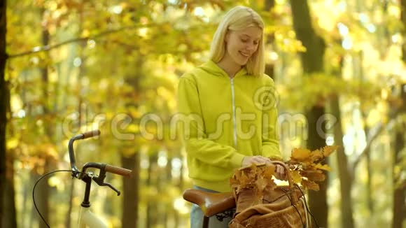 女孩们抱着带花篮的旧自行车车把假日户外度假之旅秋天的女人视频的预览图