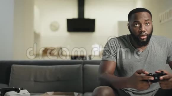 微笑的黑人男子在家厨房玩电子游戏视频的预览图