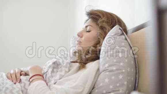 睡在卧室里的漂亮女人从恐怖梦中醒来的女性视频的预览图