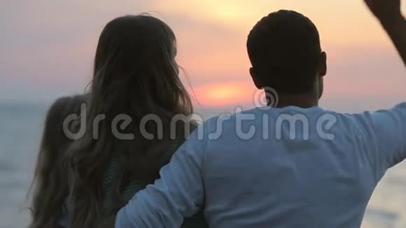 日落时分一家人坐在海边丈夫视频的预览图