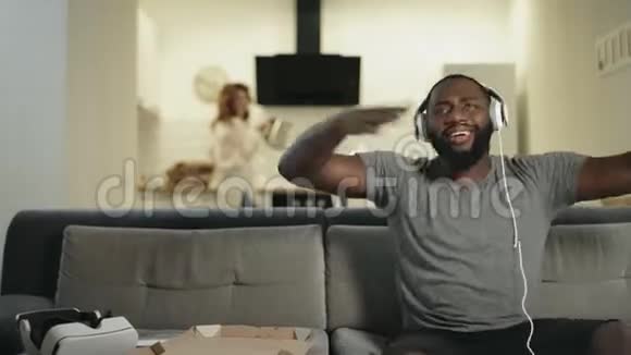 黑人在家跳舞手举起来有趣的家伙坐在耳机里视频的预览图