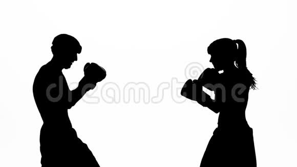 戴着拳击手套的男人在拳击场上打剪影白色背景慢动作视频的预览图