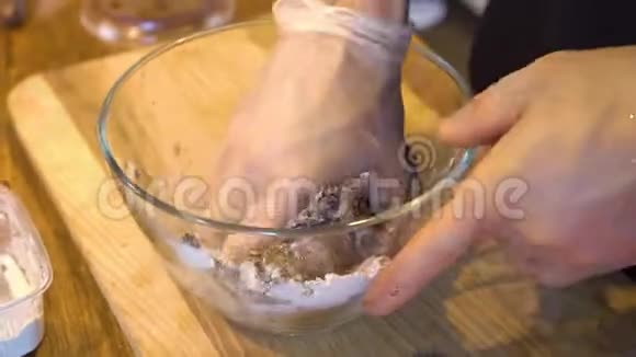 男人的手在碗里揉巧克力面团视频的预览图