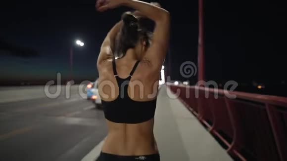 运动女性在夜间城市慢跑前热身视频的预览图