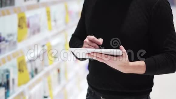特写镜头男人的手使用数码平板电脑在模糊的背景上交易货架视频的预览图